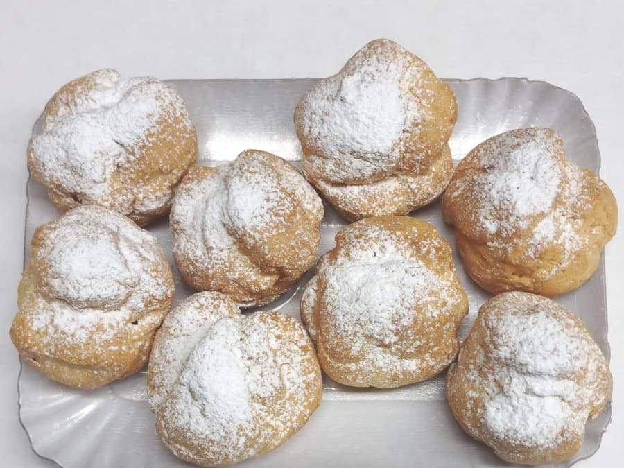 A tray of bignè di Orentano dusted with icing sugar