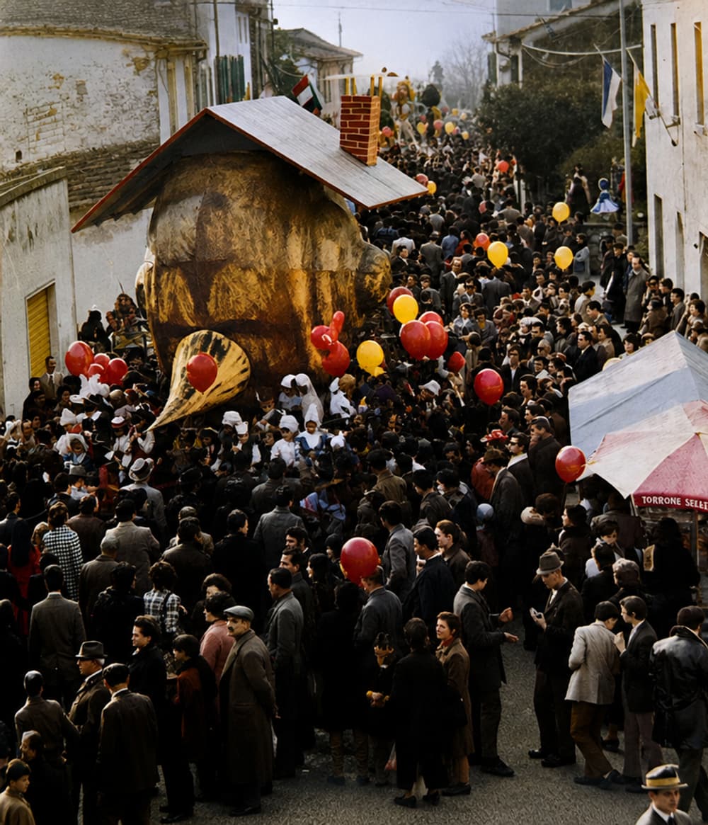 Eine Farbfotografie der Menge, die die Dorfstraße um einen allegorischen Festwagen füllt, überall Luftballons