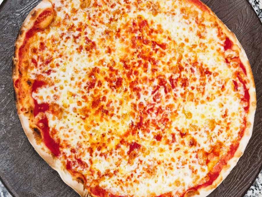 A pizza orentanese, thin and crisp with a golden raised edge, straight from the oven floor